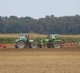 dwa traktory stojące w polu